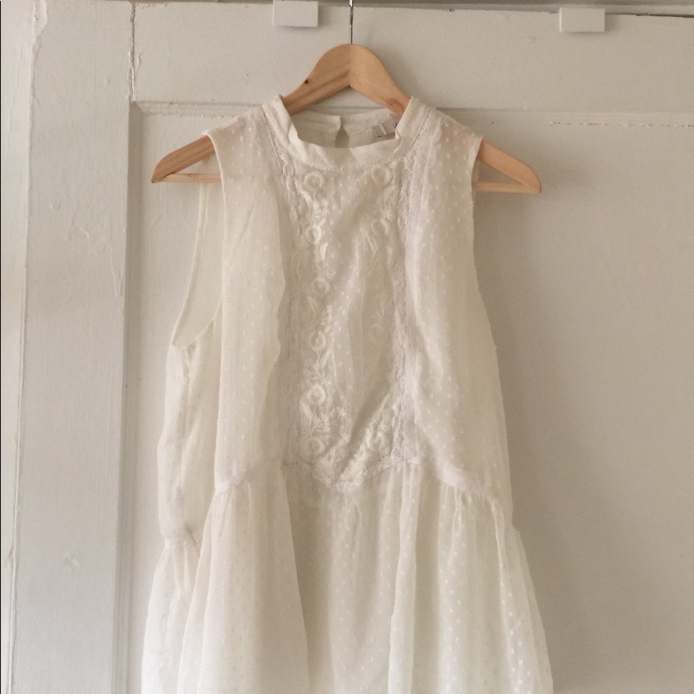 White sleeveless peplum top with embroidery
